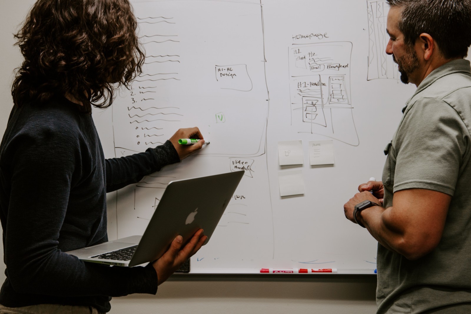 Person drawing up a site design on a whiteboard